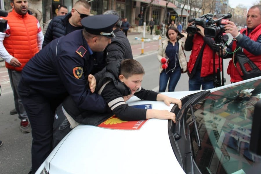 Policia dhe ligji: Fëmija mbi makinën e policisë për të ndaluar arrestimin e prindërve që po mbronin shtëpinë e tyre nga fantazma …drejtësi (Video)